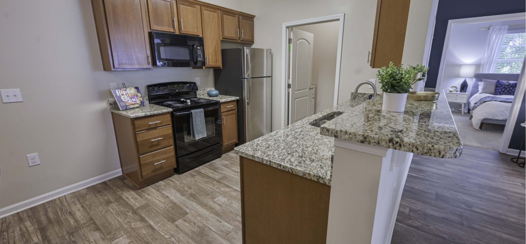 Hawthorne at Murrayville modern kitchen with wooden cabinets, stainless steel appliances, and a granite countertop
